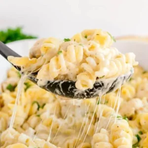 Delicious Chicken Alfredo Pasta Bake topped with cheese and herbs.