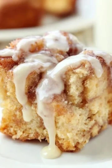 Delicious cinnamon roll casserole topped with icing and cinnamon sugar.