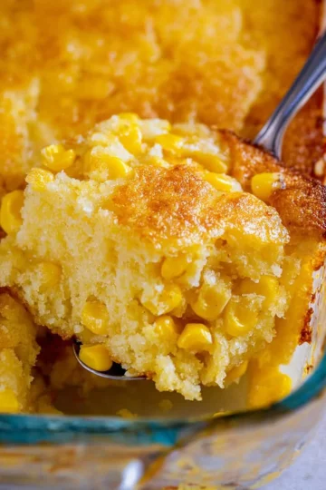 Creamed cornbread casserole topped with golden crust and served in a baking dish