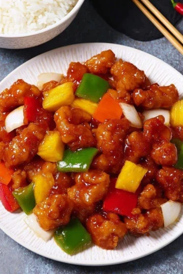 Crispy sweet and sour chicken served with vibrant vegetables