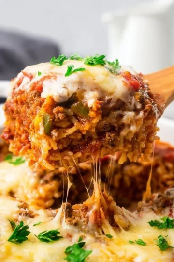Delicious stuffed pepper casserole topped with cheese and fresh herbs