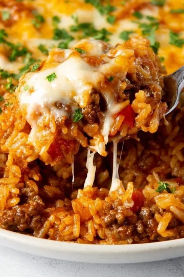 Taco casserole with rice, featuring layers of beef, cheese, and toppings.
