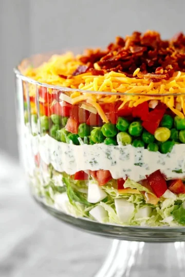 Colorful 7 Layer Salad with fresh ingredients in a glass dish