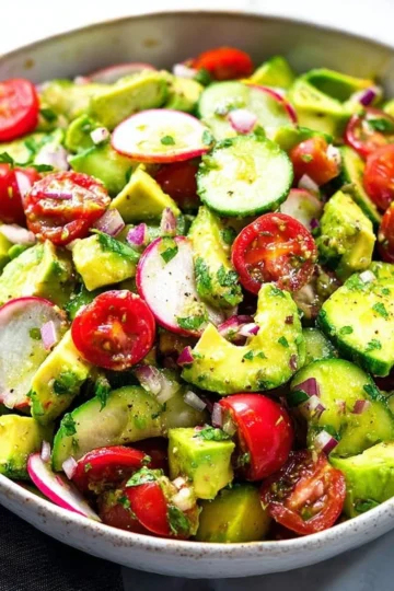 Delicious avocado salad with fresh vegetables and dressing