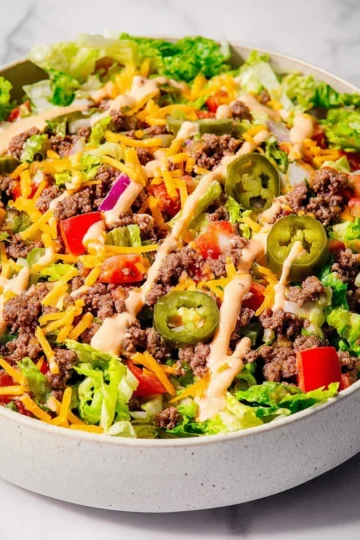 Big Mac Salad with lettuce, tomatoes, cheese, and special sauce in a bowl