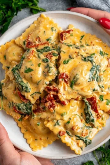 Creamy Tuscan ravioli served in a rustic Italian bowl garnished with herbs