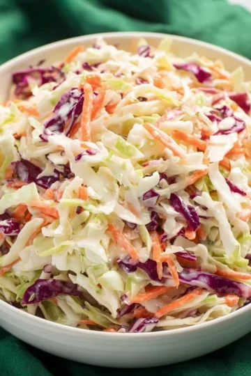 Bowl of easy cole slaw with fresh vegetables and dressing