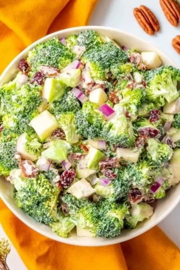 Delicious fall broccoli salad with pecans, apples, and craisins in a bowl