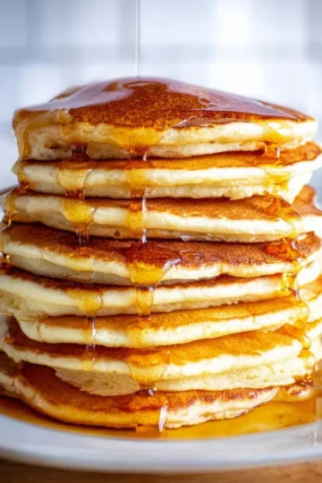 Fluffy almond flour pancakes stacked with syrup and berries