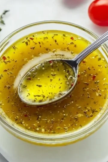 Fresh Greek salad dressing with olive oil, lemon juice, and herbs