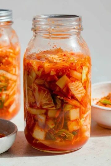 Homemade kimchi prepared with fresh vegetables and spices in a ceramic jar.
