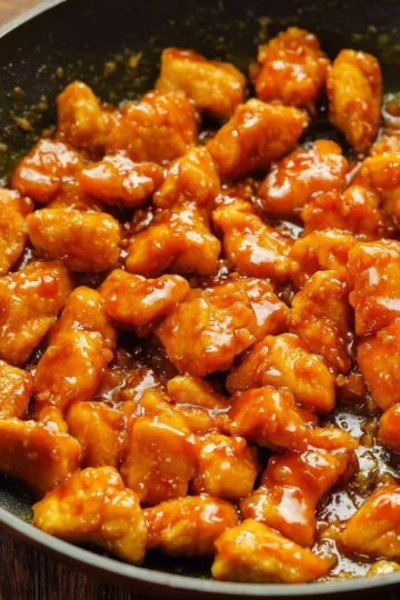 Delicious plate of honey garlic chicken with vegetables on a wooden table
