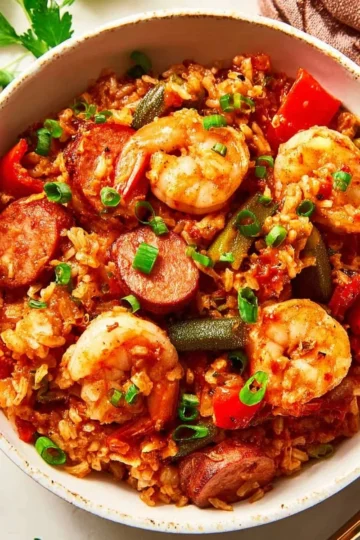 Delicious bowl of jambalaya with shrimp, chicken, and sausage garnished with parsley.