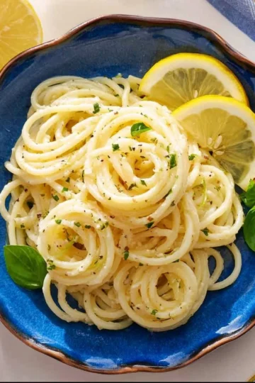 Delicious lemon pasta served in a bowl with fresh herbs and grated cheese