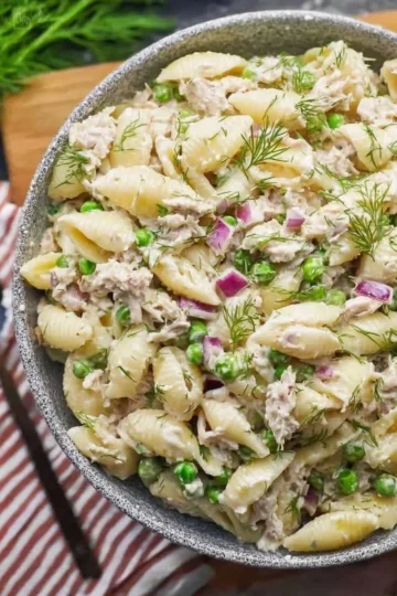Colorful bowl of tuna pasta salad with vegetables and dressing