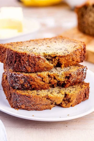 Freshly baked Banana Nut Bread with walnuts and ripe bananas on a wooden table.