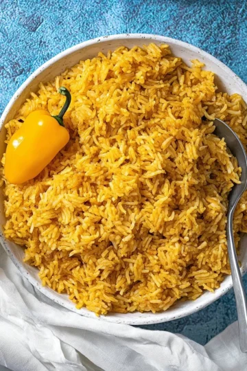 A vibrant plate of Jollof Rice garnished with vegetables and spices