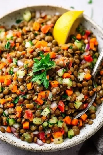 Colorful lentil salad with fresh vegetables and herbs in a bowl