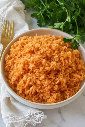 Delicious Mexican rice recipe served in a colorful bowl with garnishments