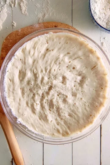 Homemade sourdough starter in a glass jar with flour and water ingredients