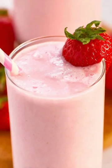 Delicious strawberry yogurt smoothie in a glass with fresh strawberries