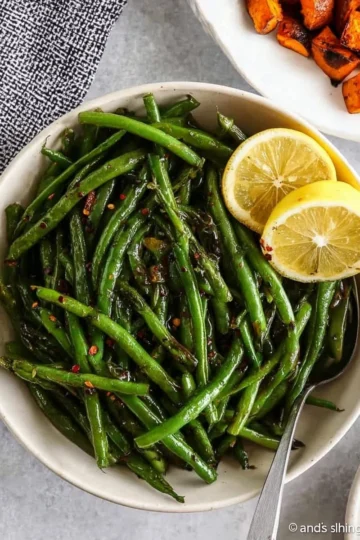 Sautéed green beans with garlic on a plate, ready to serve as a tasty side dish.