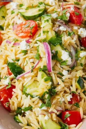 A vibrant bowl of the best orzo pasta salad with fresh vegetables and dressing.